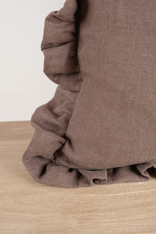 A Brown linen cushion featuring a frilled gathered edging. 100% Irish Linen, Woven and Made in Ireland. This linen has a beautiful laundered finish which leaves a textured natural finish to the cushion