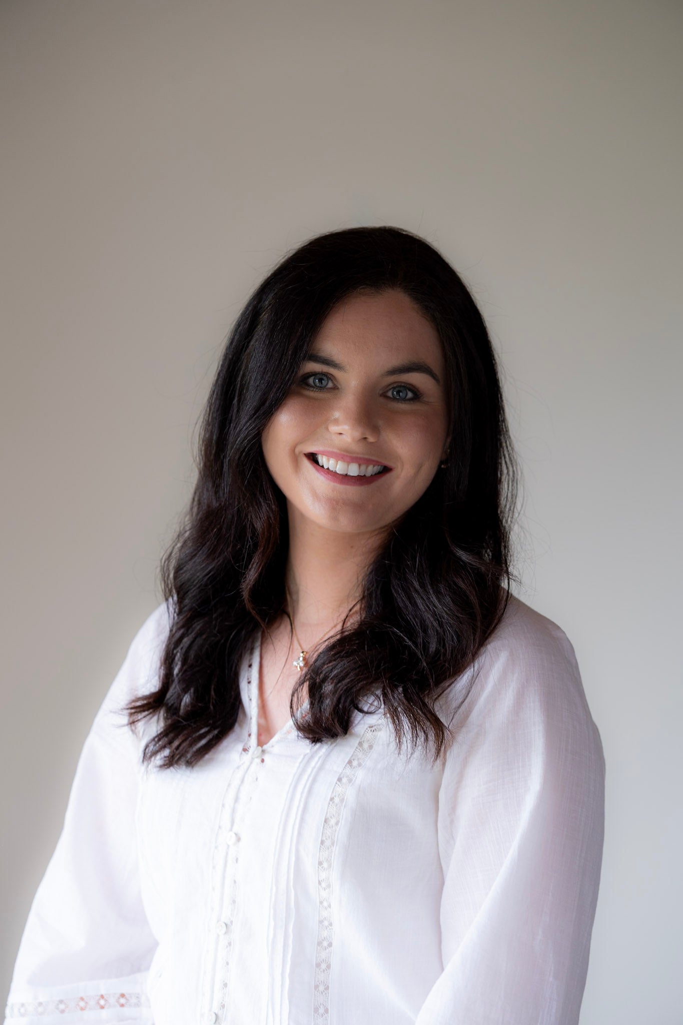 sinead kenna wearing a white blouse against a plain background