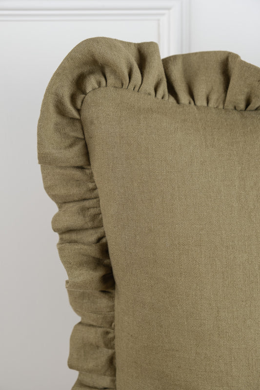 A Olive linen cushion featuring a frilled gathered edging. 100% Irish Linen, Woven and Made in Ireland. This linen has a beautiful laundered finish which leaves a beautiful textured natural finish to the cushion