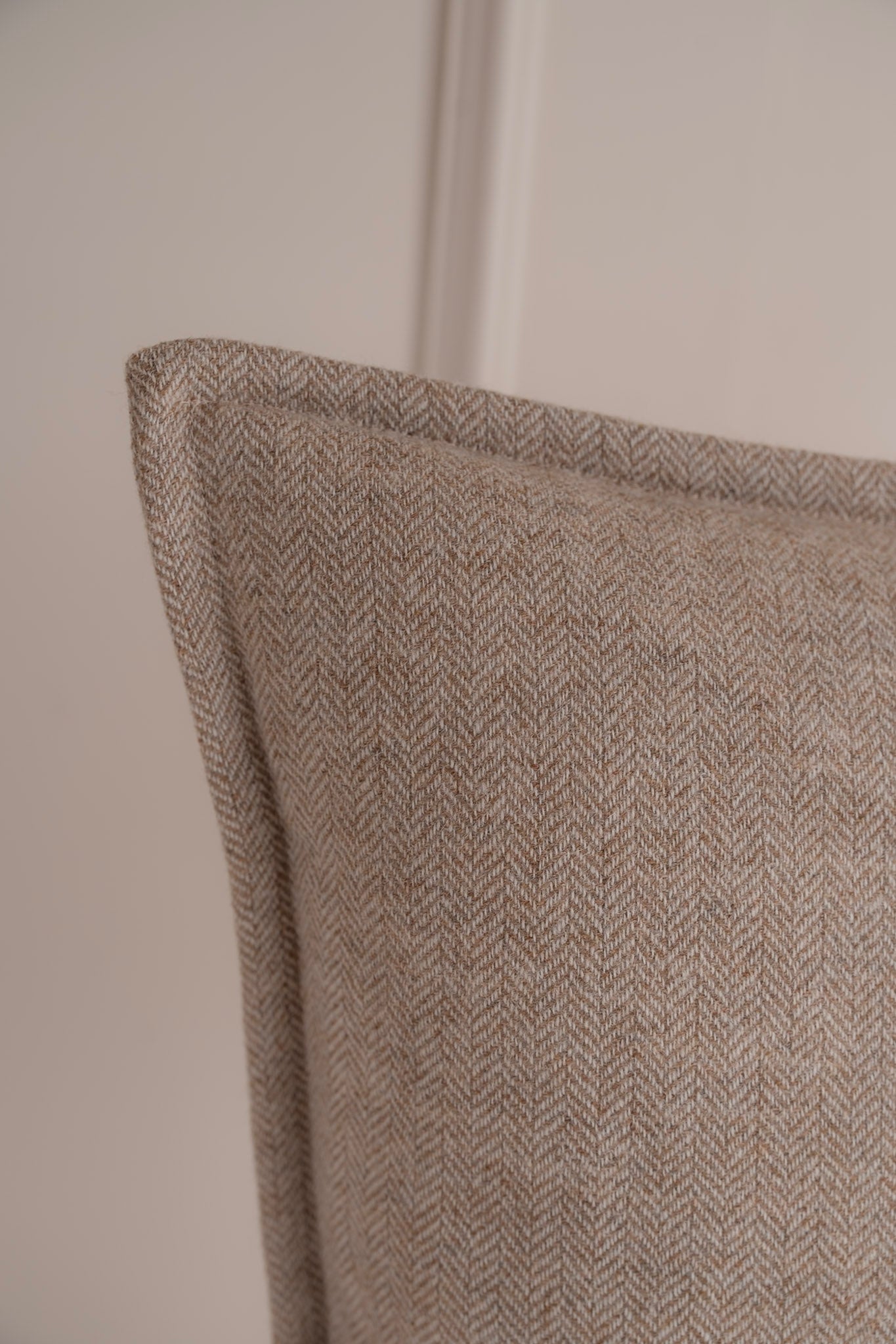 A close up of a neutral herringbone tweed cushion. Irish Tweed. 100% Pure New wool. Handmade in Ireland