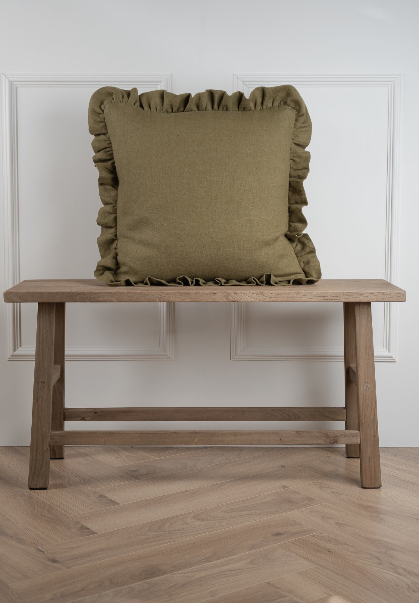 A green, olive green coloured cushion with a wide frilled design, handmade in Ireland. 